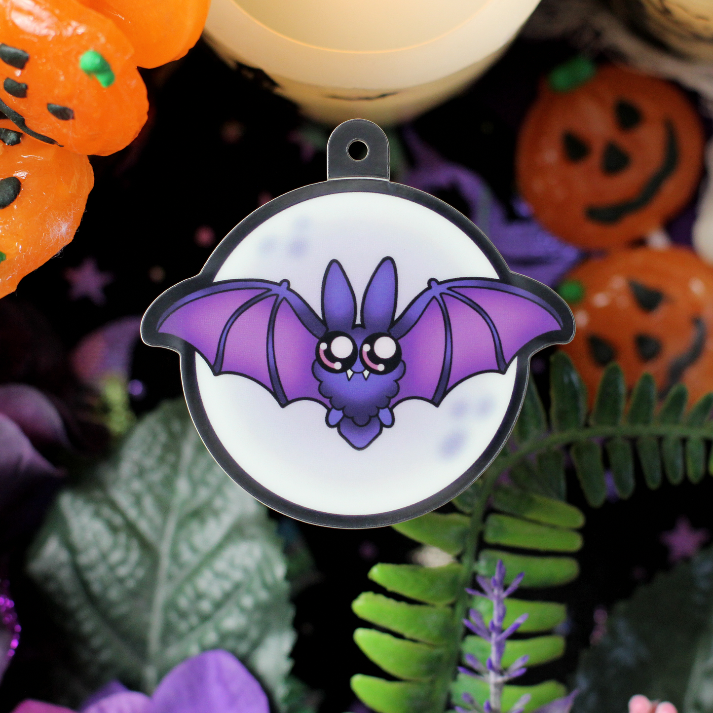 glow in the dark bat sticker with cute big eyes and fangs, set against a full moon.