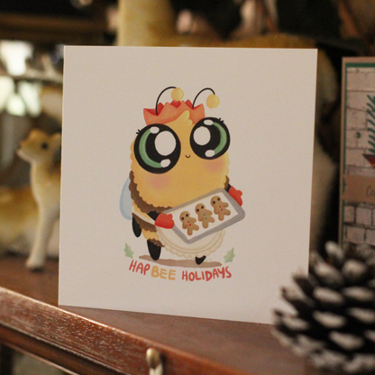 bee themed christmas greeting card sitting on a mantelpiece. The bee is holding gingerbread cookies